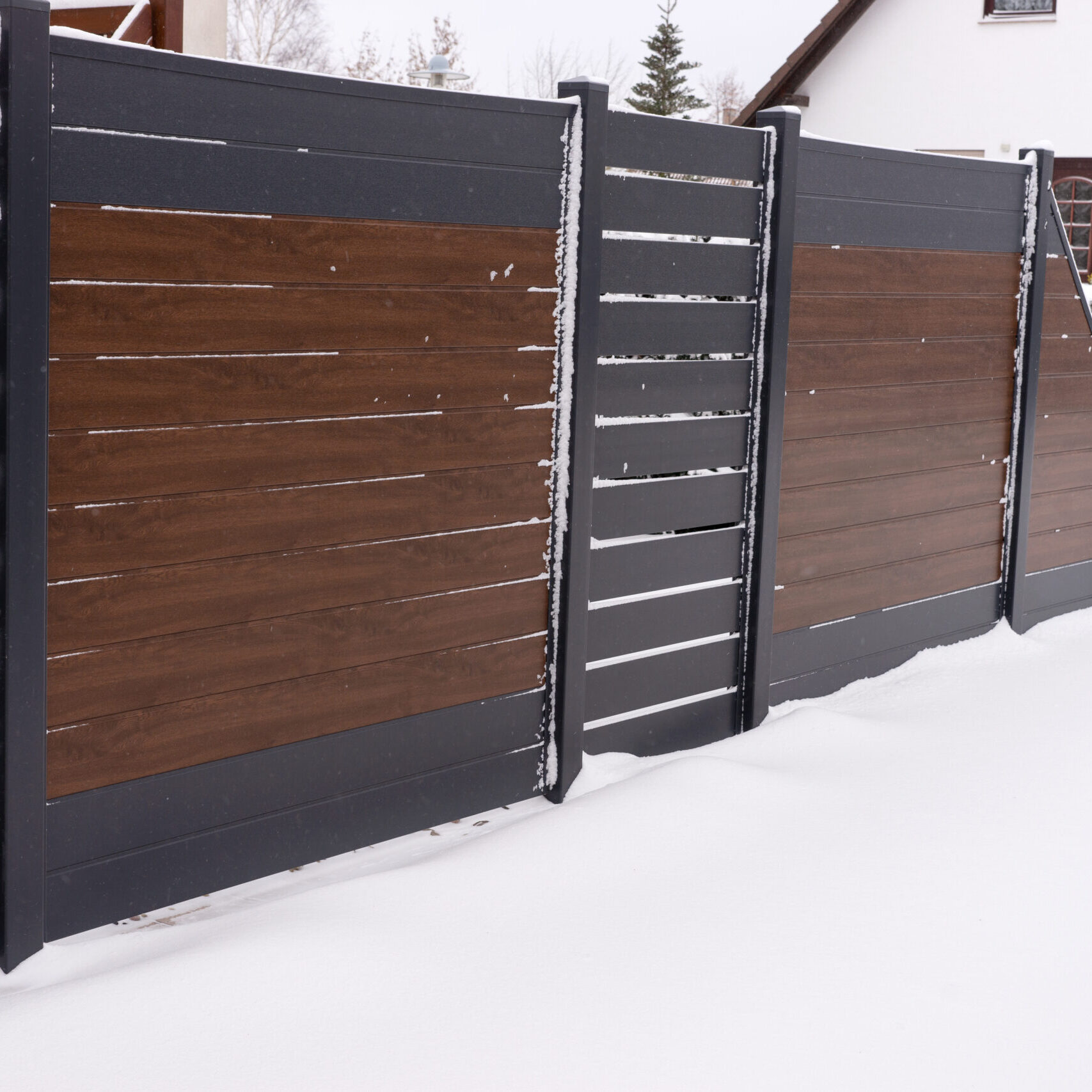 New stylish high plastic fence in winter. Vinyl products. Protection of the house