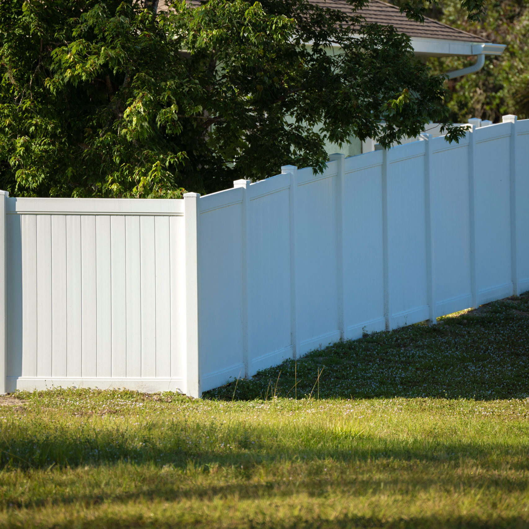 White plastic fence for back yard protection and privacy.